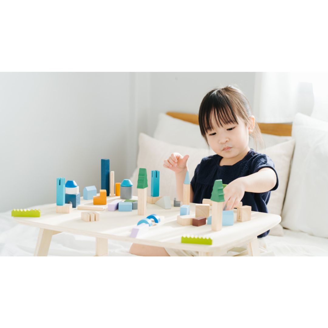 Child playing with colorful wooden blocks on a table