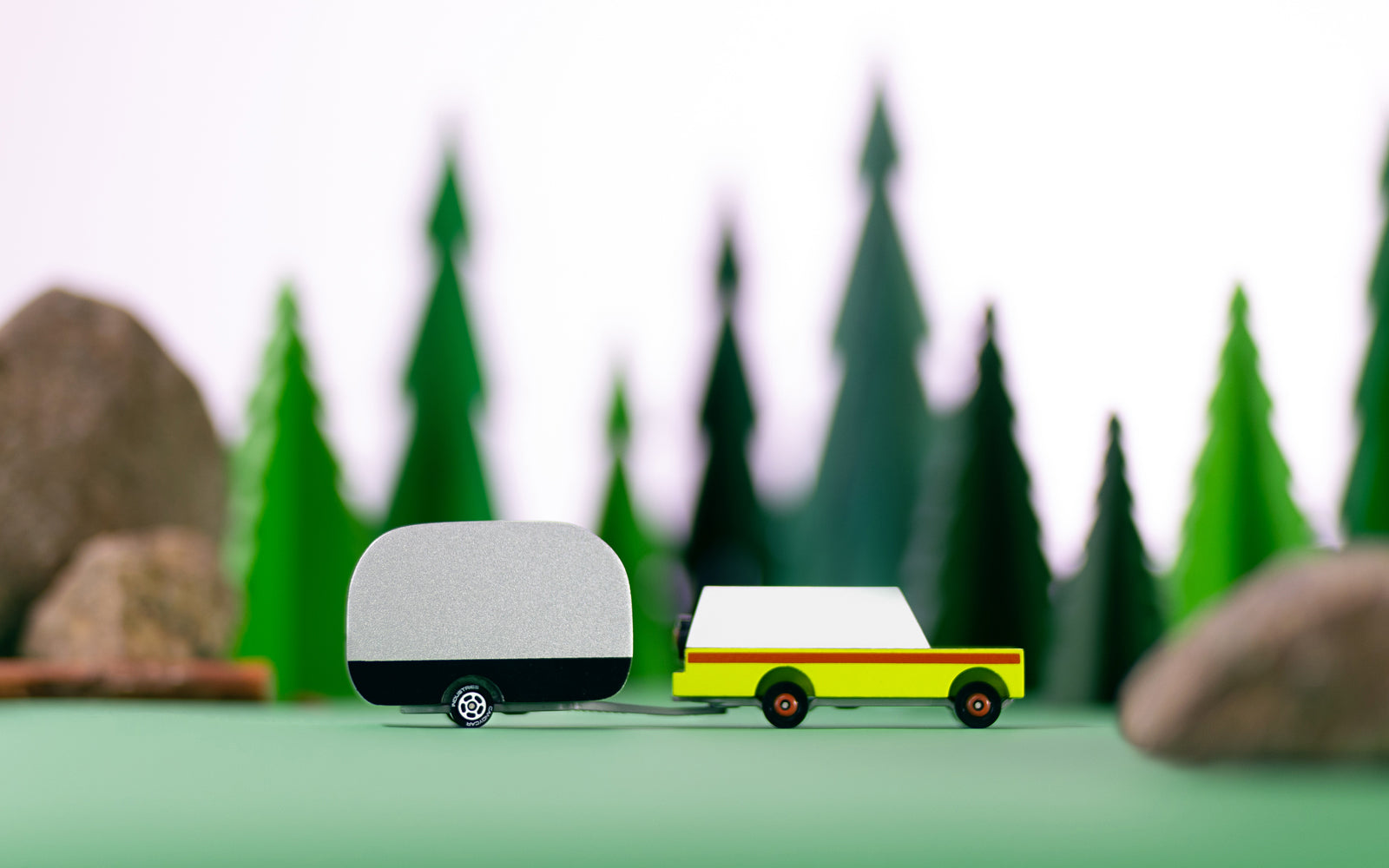 Model truck with a trailer in front of a forest background