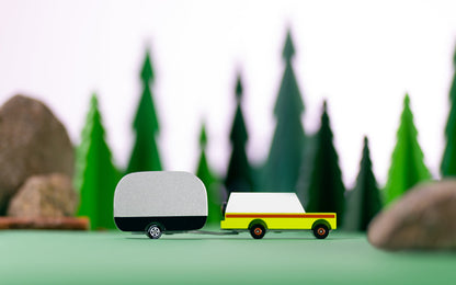 Model truck with a trailer in front of a forest background