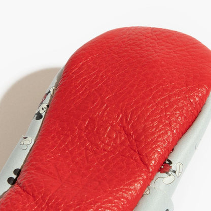 Close-up of a red leather seat with metal accents on a motorcycle.