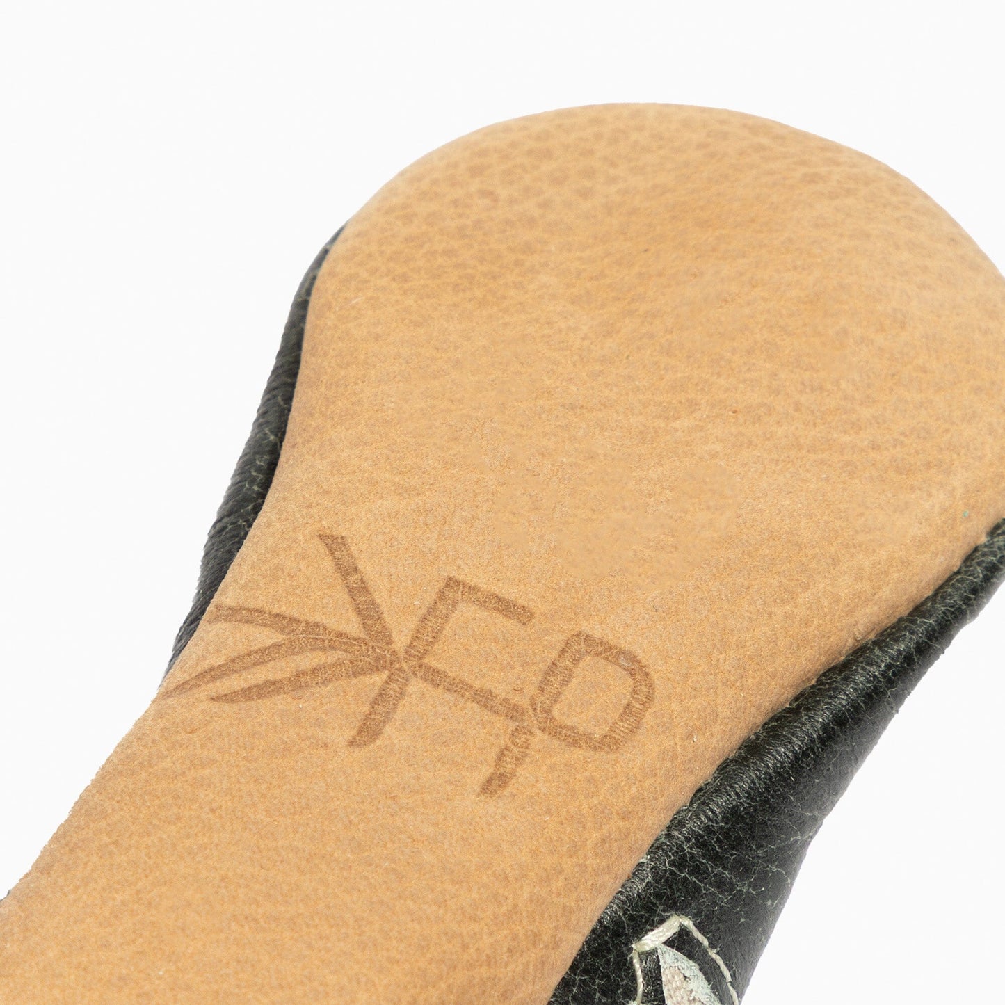 Close-up of a tan insole with a brand logo on a white background
