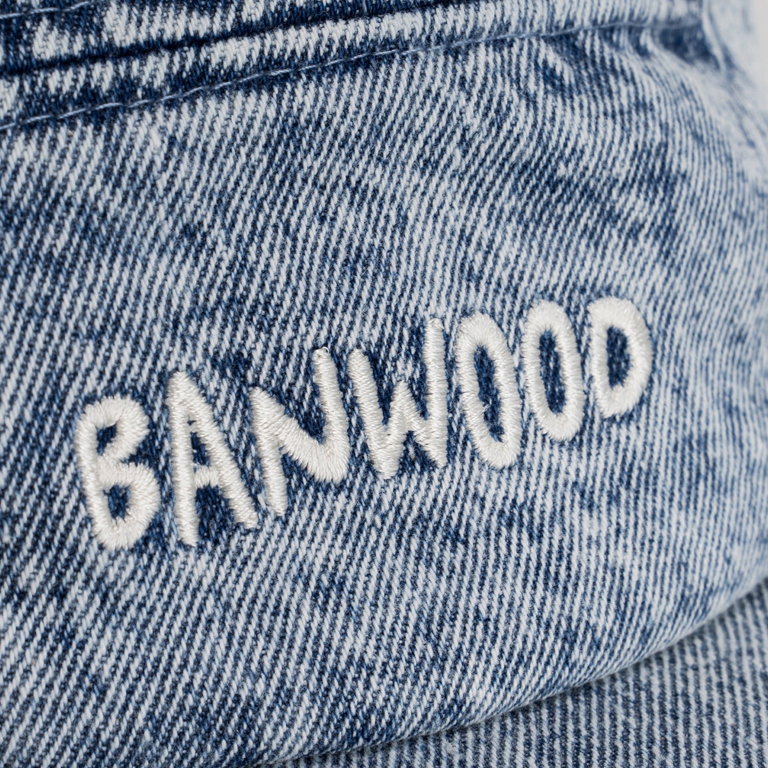 Close-up of denim fabric with 'BANWOOD' embroidery