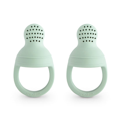 Two mint green silicone teething rings on a white background