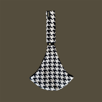 Black and white houndstooth patterned dog toy on a brown background