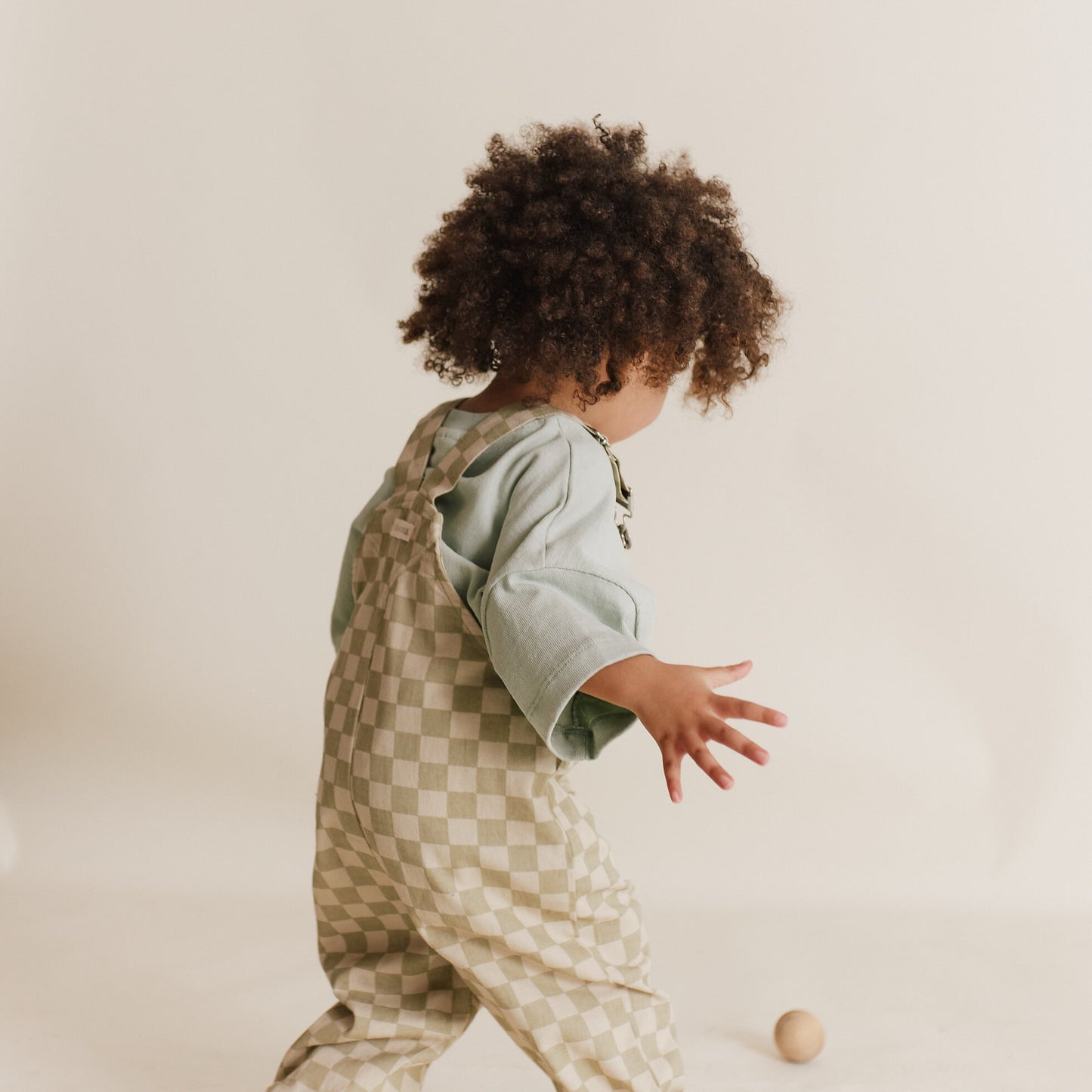Child wearing a checkered outfit with a plain background