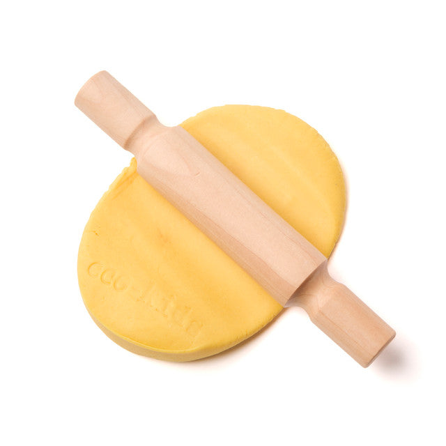 Wooden rolling pin on a ball of yellow dough with 'Cocoon' branding.
