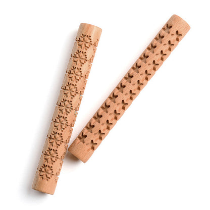 Two wooden rolling pins with embossed patterns on a white background