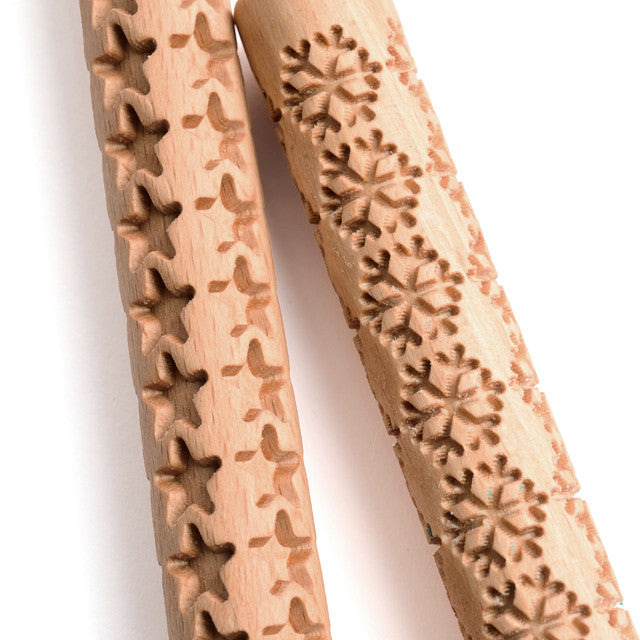 Two wooden cookie cutters with floral patterns on a white background