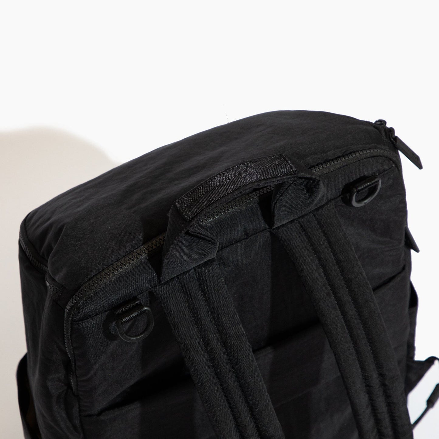 Black backpack with multiple straps on a white background