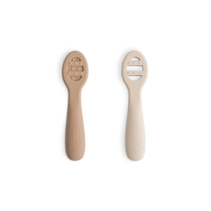 Two beige baby spoons on a white background