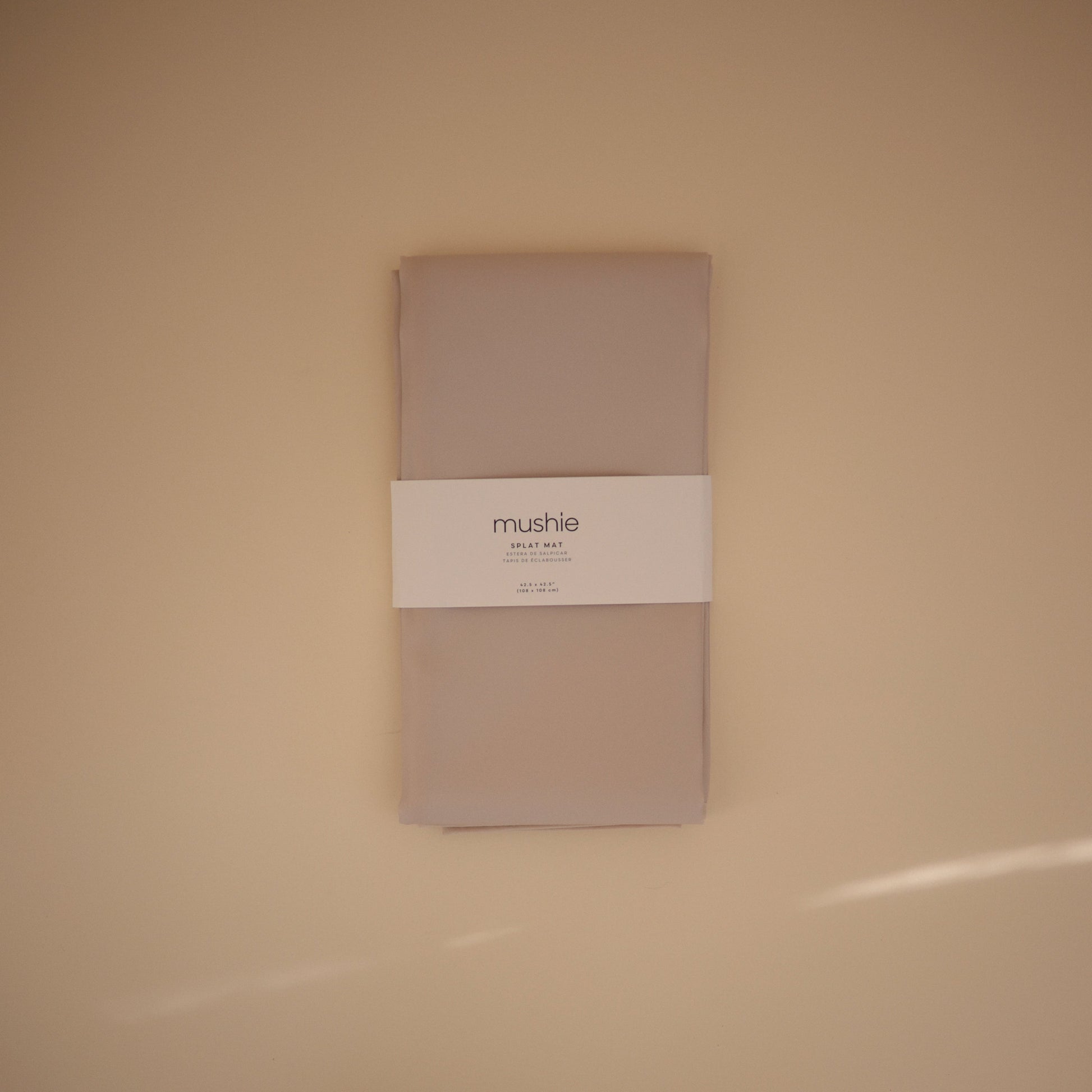 Folded beige fabric with a white label on a beige background