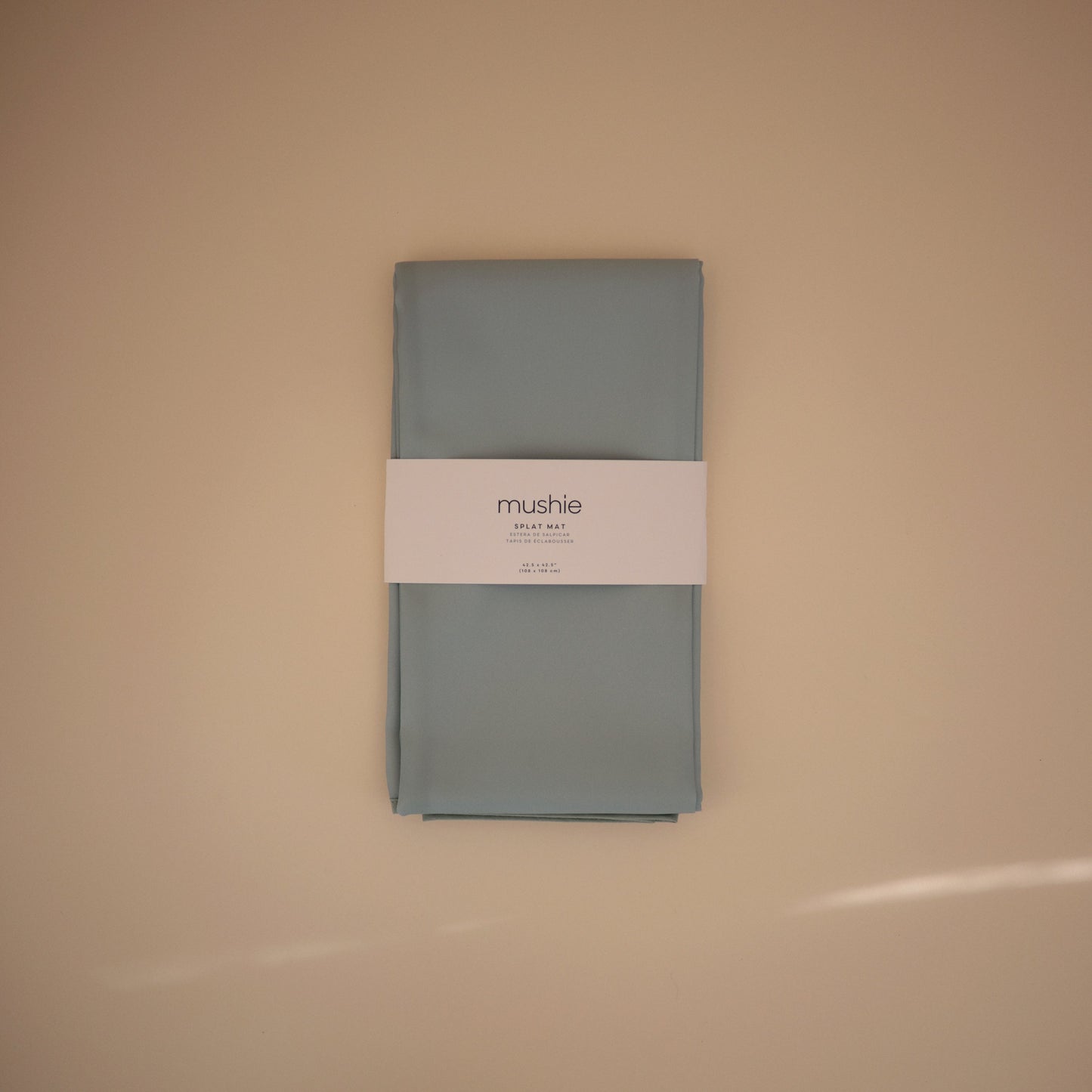 Folded gray fabric with a visible brand label on a beige background