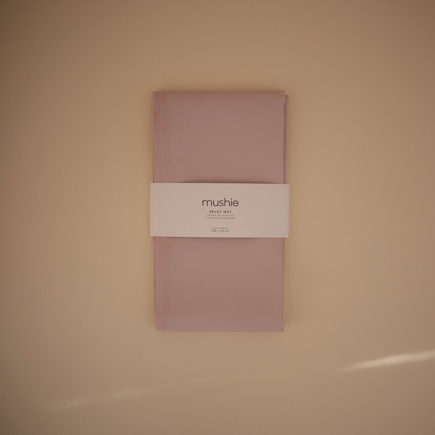 Pink fabric package with a label on a beige background