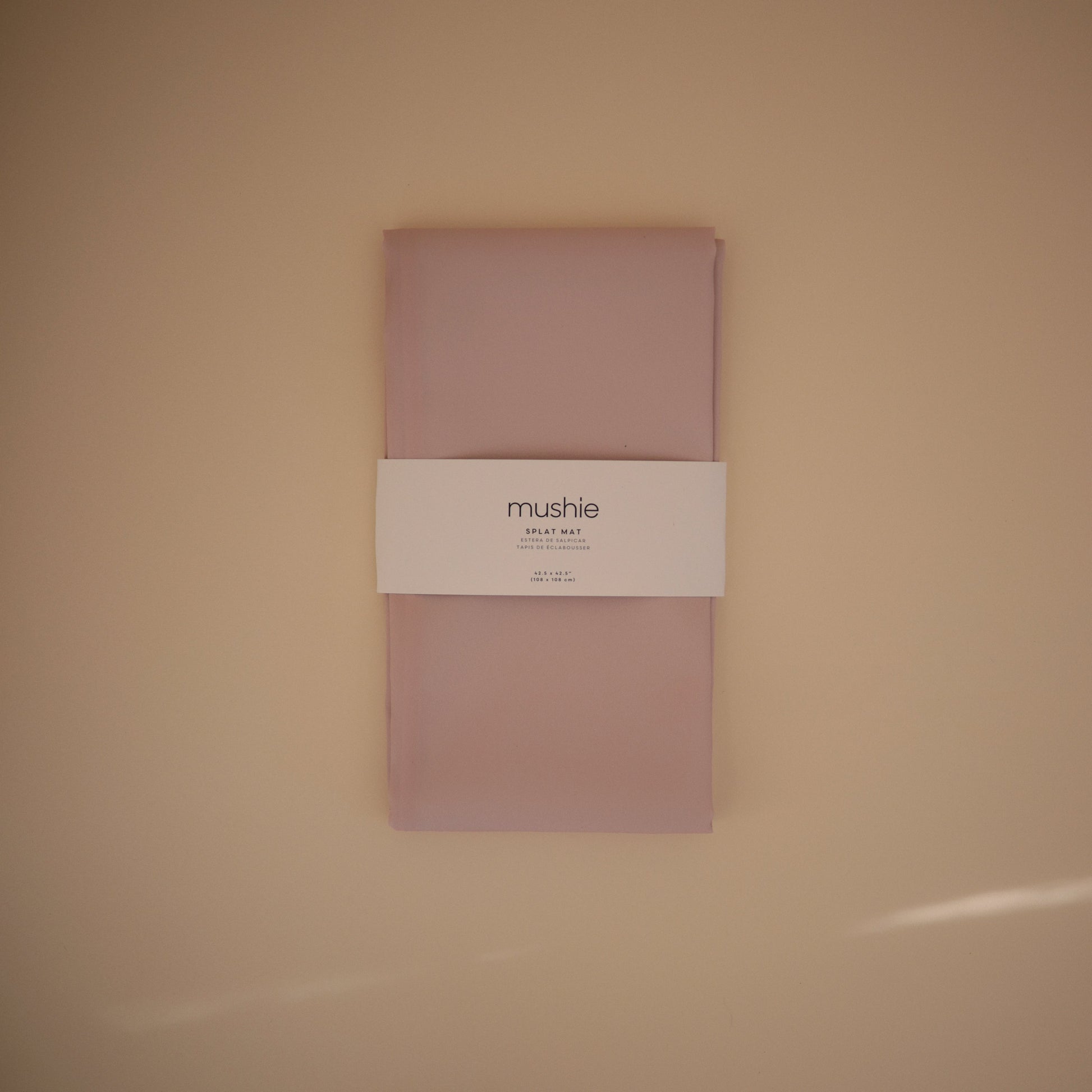 Pink fabric package with a label on a beige background