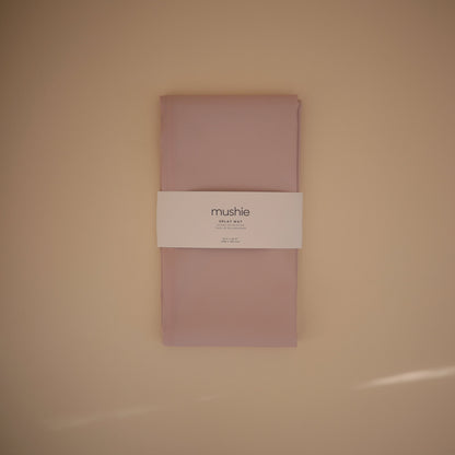 Pink fabric package with a label on a beige background