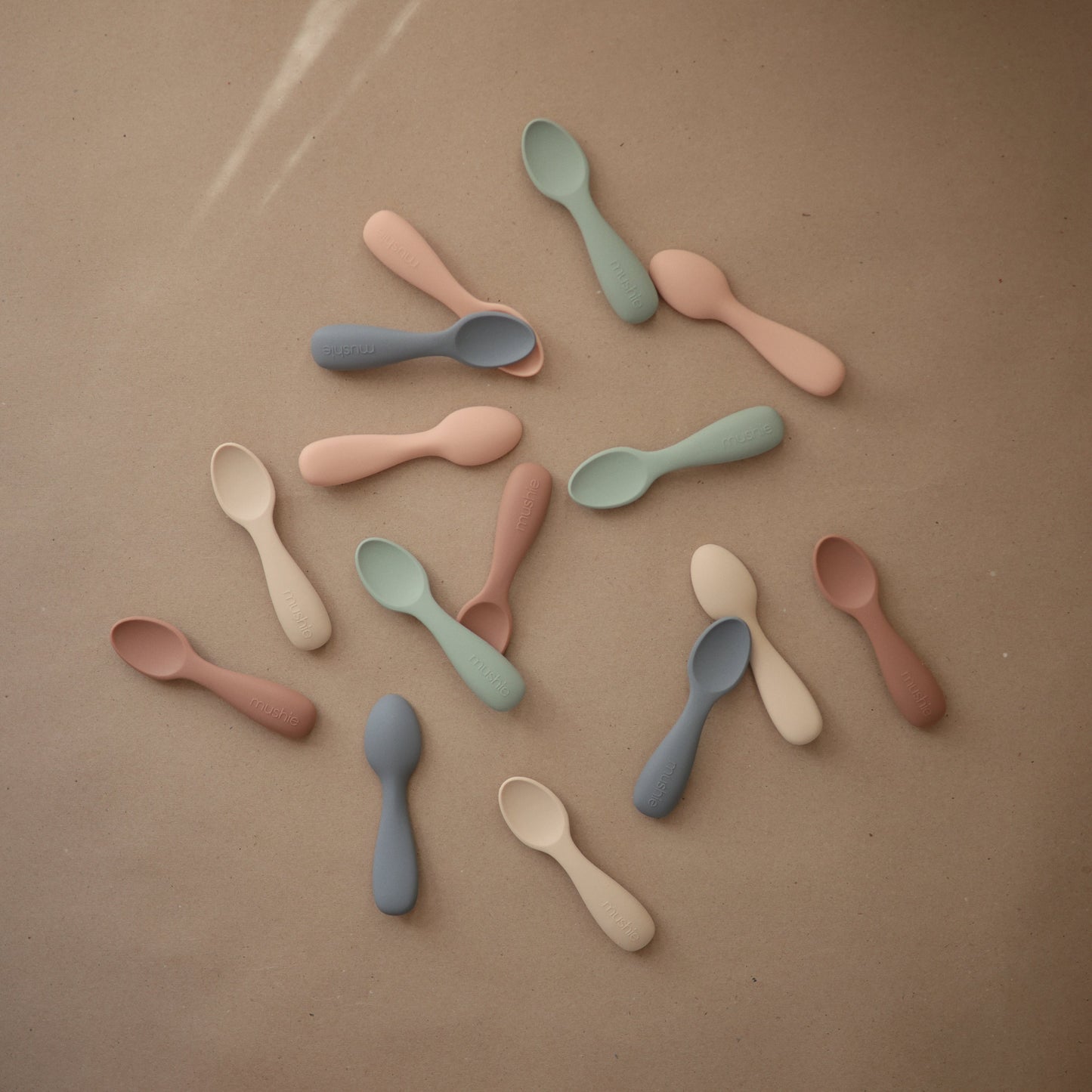 Colorful spoons arranged on a brown surface