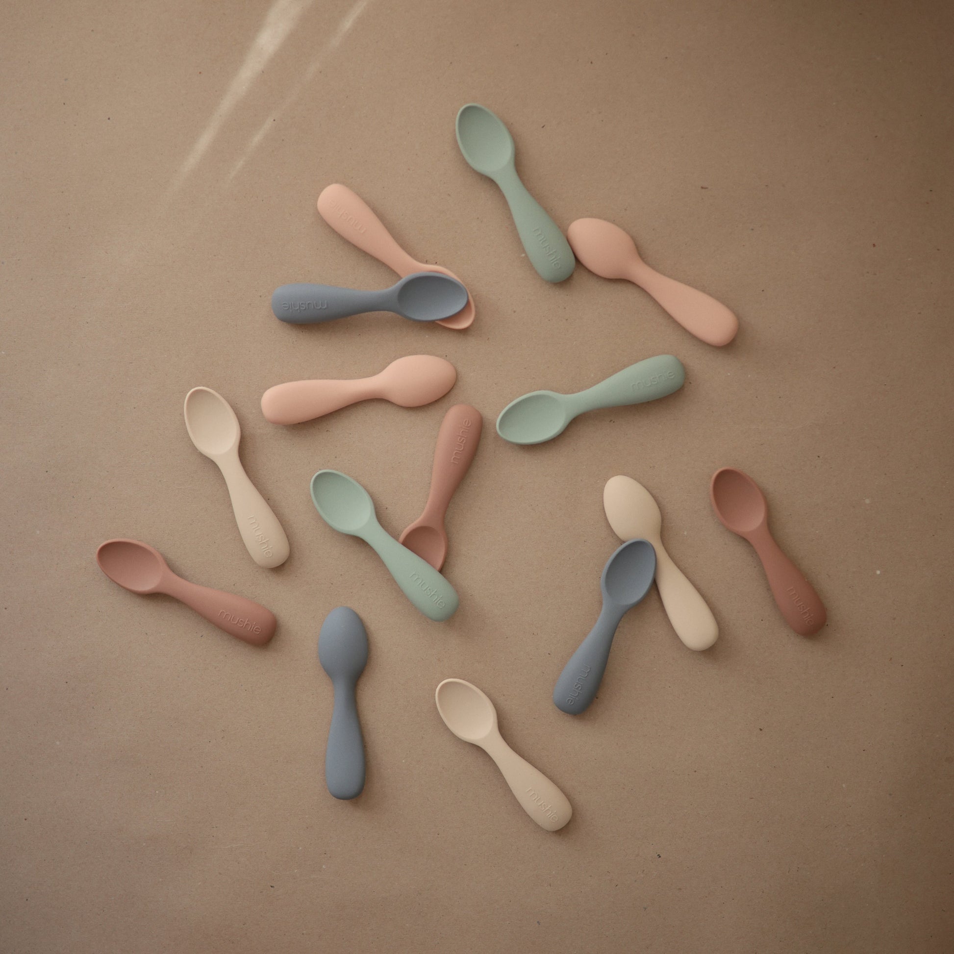 Colorful spoons arranged on a brown surface