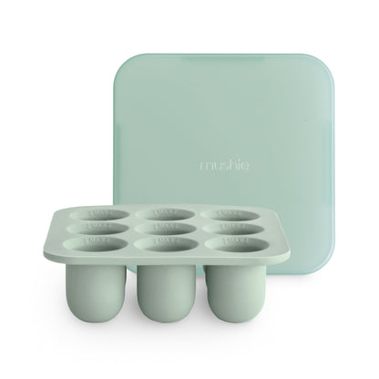 Mint green silicone ice cube tray with lid on a white background