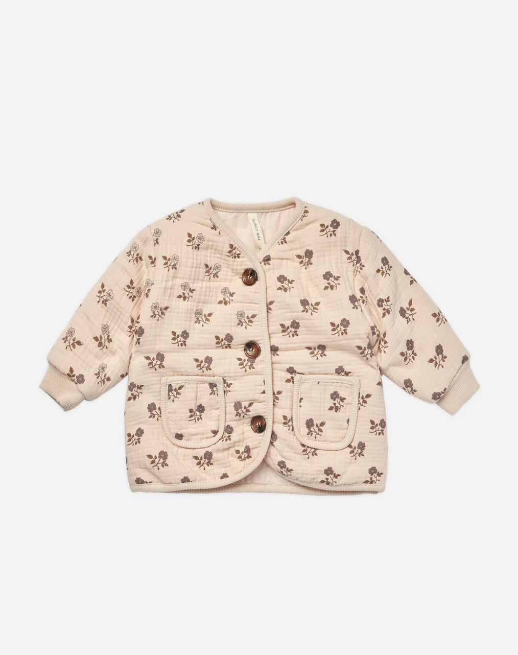 A quilted v-neck button jacket with a 'fig flora' floral pattern on a beige background, featuring two front pockets and buttons down the front.