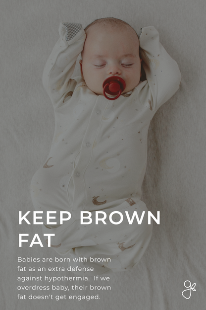 Baby in a white onesie with a pacifier, lying on a light gray surface.