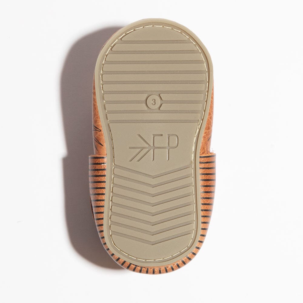 Close-up of a sandal sole with a brand logo on a white background