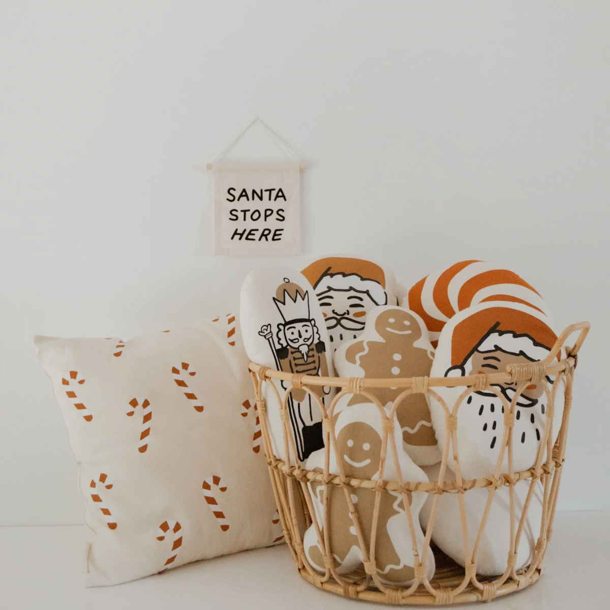 Decorative basket with Christmas-themed items including a pillow and a sign on a white background