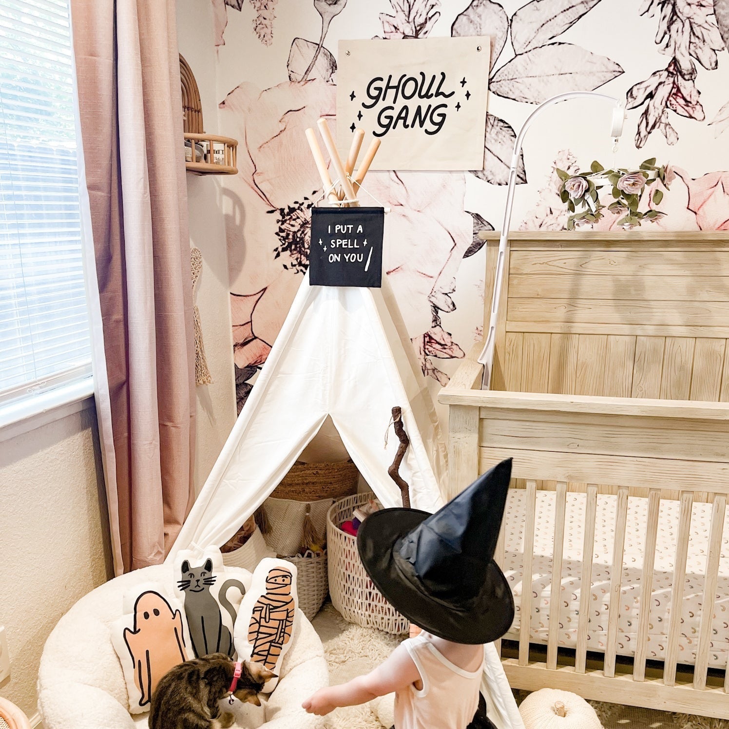 Children's room with a teepee, Halloween decorations, and a cat.