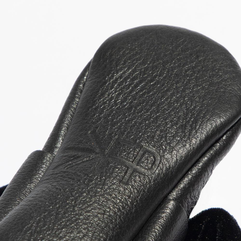 Close-up of a black leather glove with a brand logo on a white background