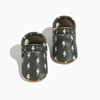 Pair of baby shoes with lightning bolt pattern on a white background