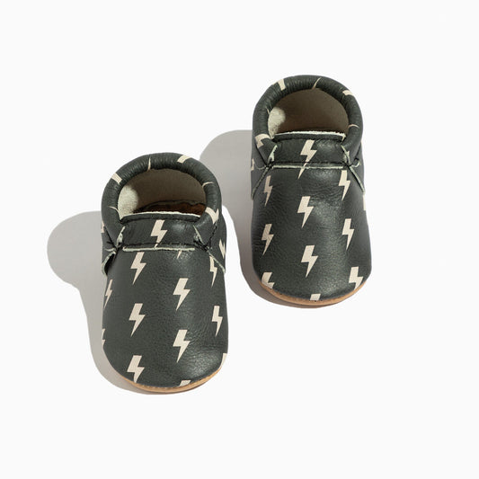 Pair of baby shoes with lightning bolt pattern on a white background