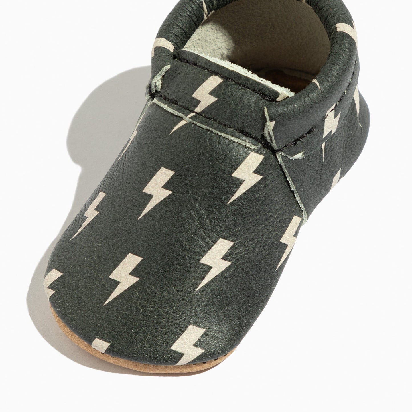 Dark gray baby shoe with white lightning bolt pattern on a white background