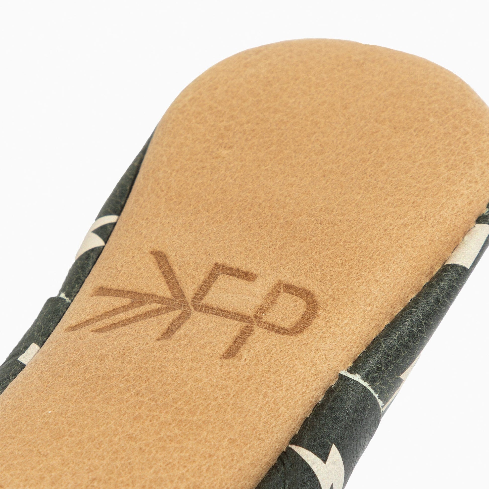 Close-up of a sandal sole with a brand logo on a white background