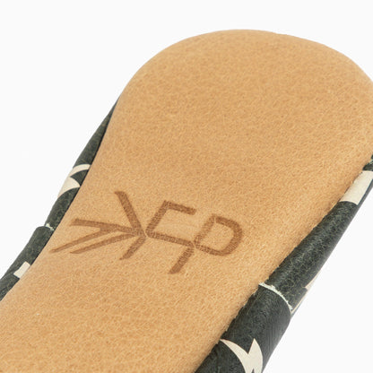 Close-up of a sandal sole with a brand logo on a white background