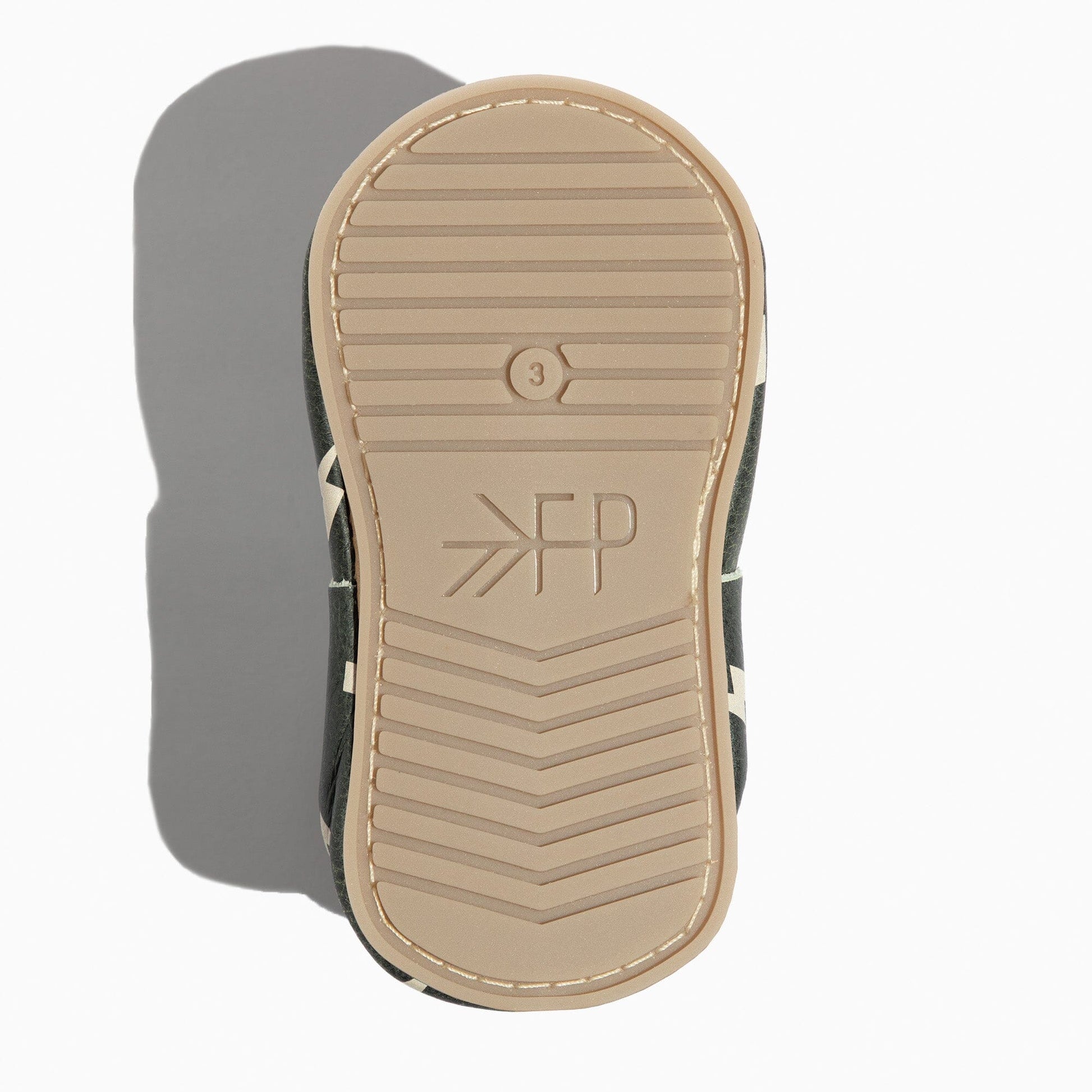 Close-up of a sandal sole with a brand logo on a white background