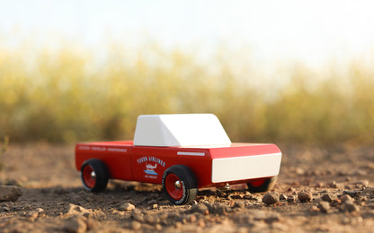 Model truck on a dirt surface with a blurred natural background