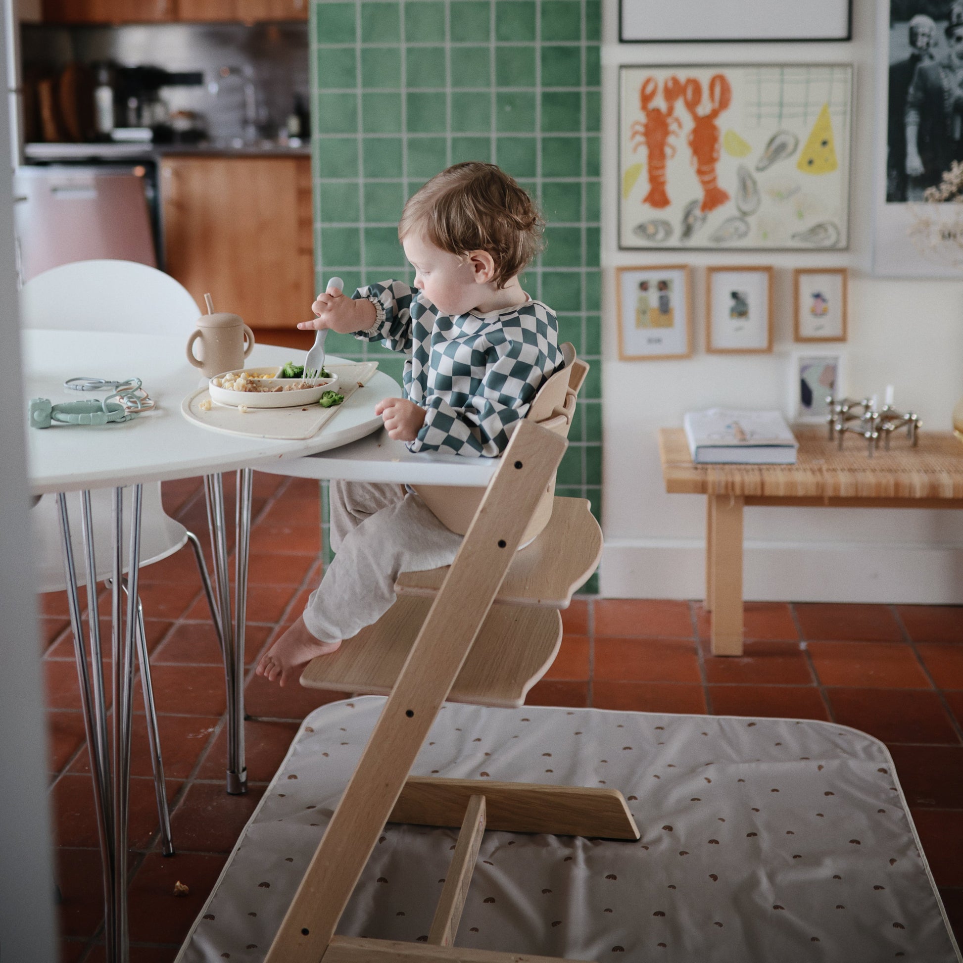 Child sitting on a wooden chair at a table in a kitchen