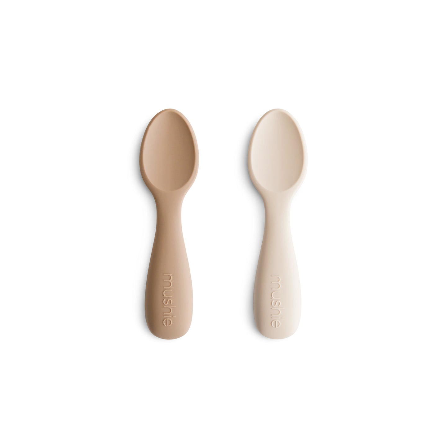Two beige silicone spoons on a white background