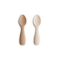 Two beige silicone spoons on a white background