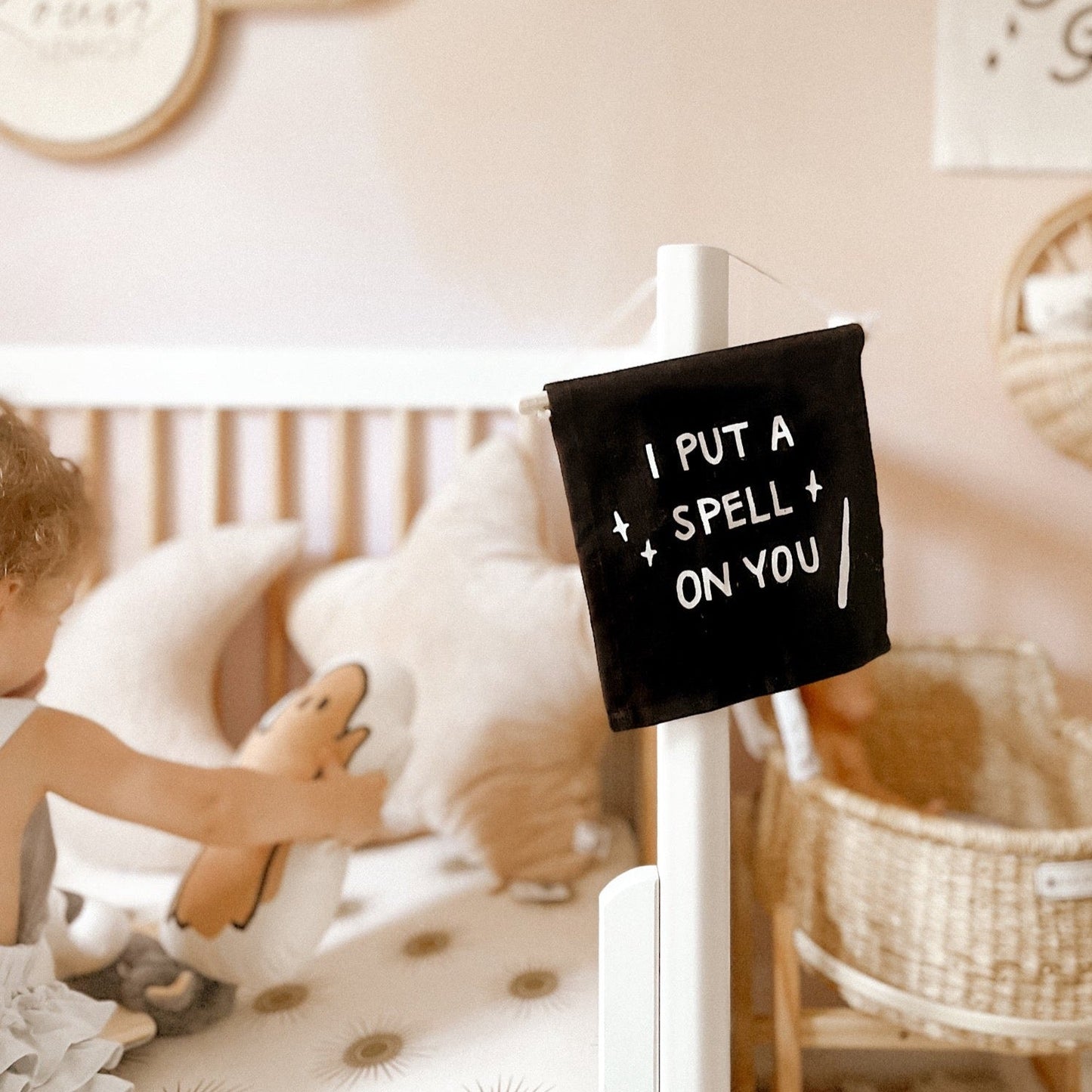 Child playing with plush toys in a cozy room with a decorative sign.