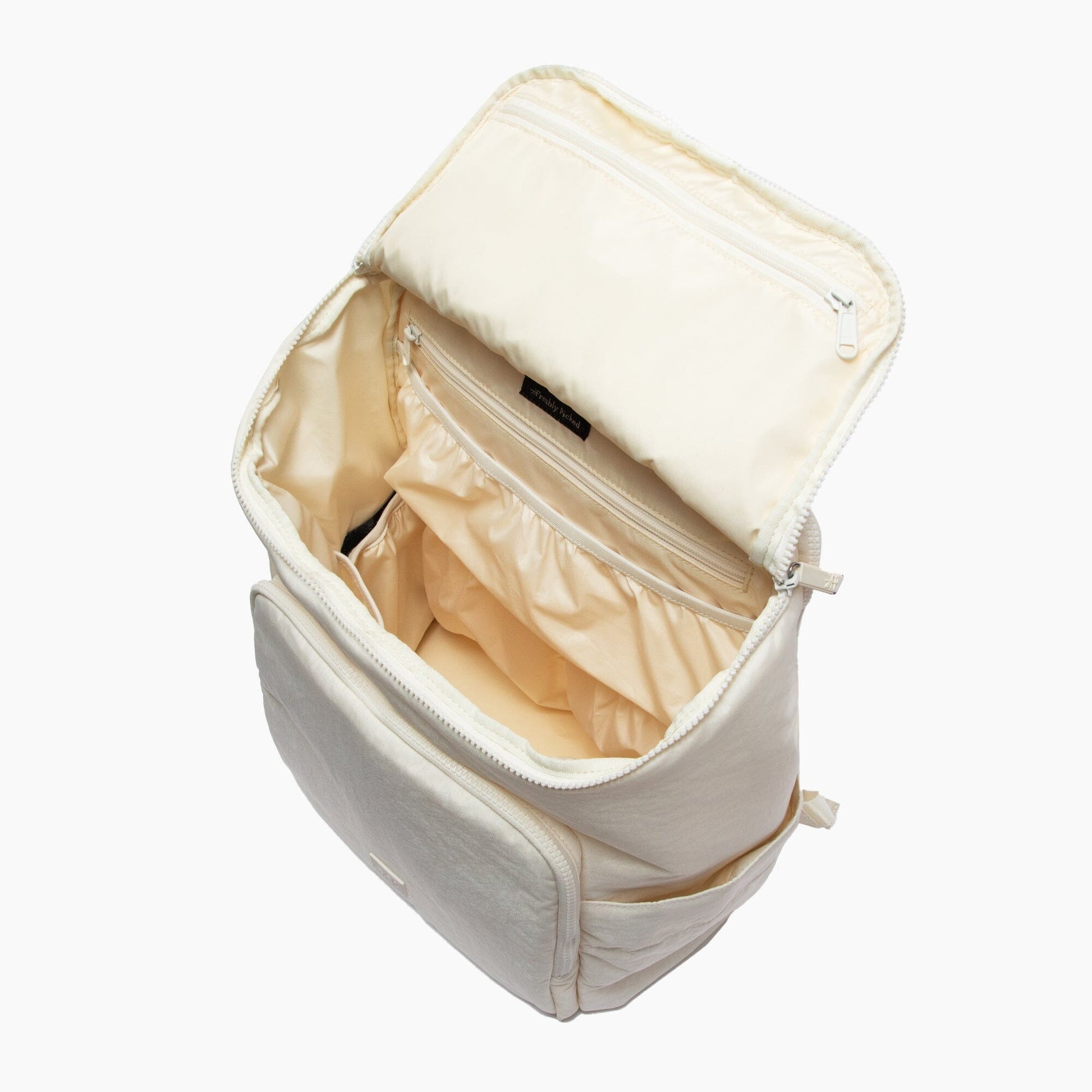 Beige toiletry bag with open compartment on a white background