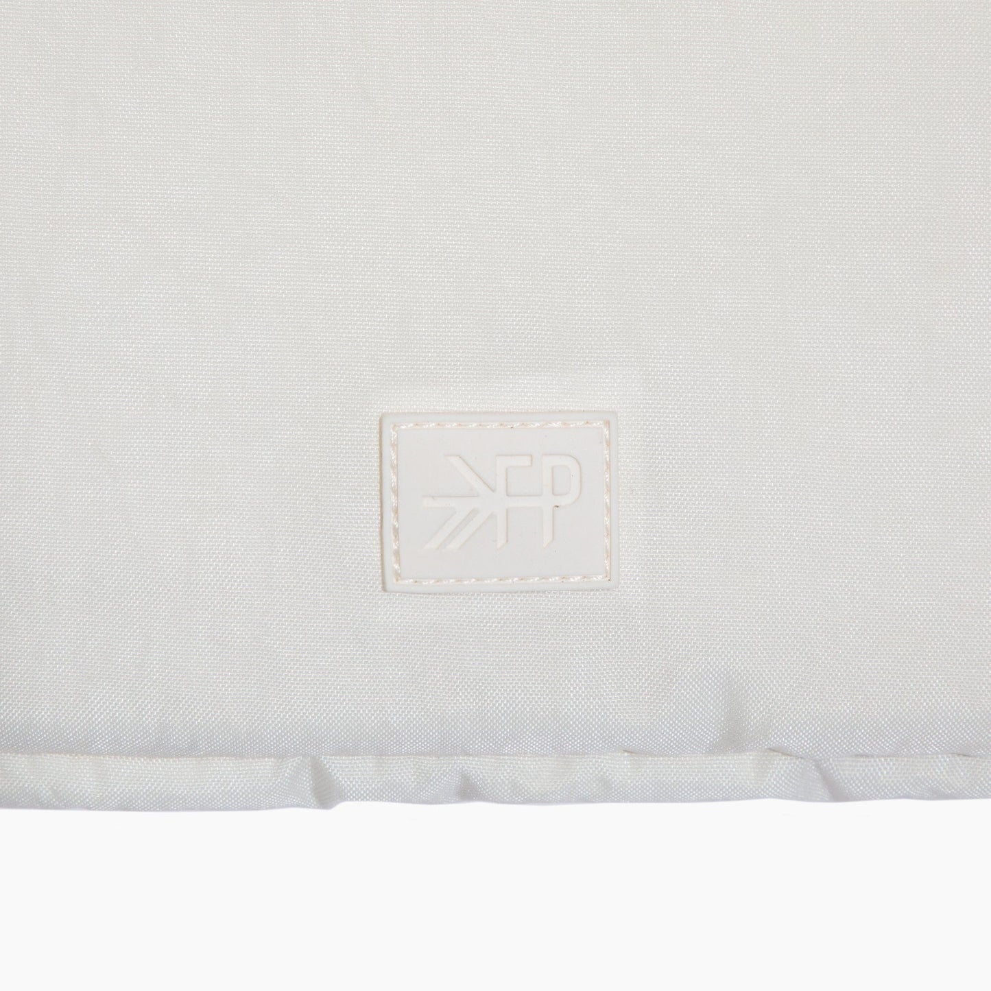 Close-up of a white mattress with a brand logo on a white background