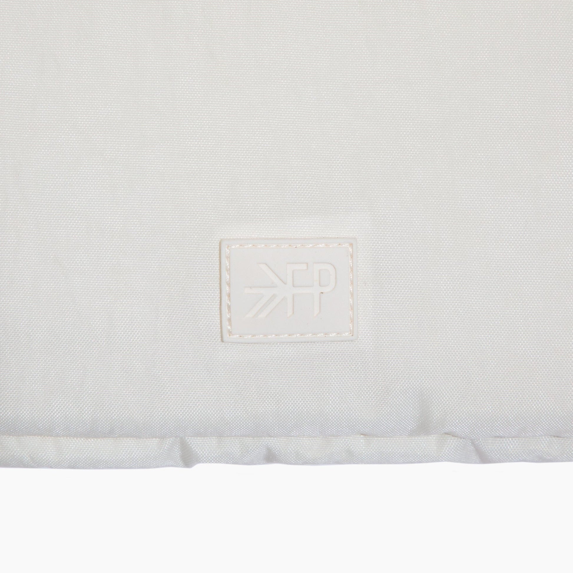 Close-up of a white mattress with a brand logo on a white background