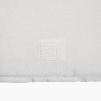 Close-up of a white mattress with a brand logo on a white background