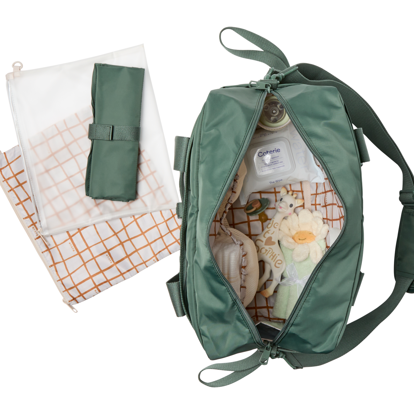 Green baby bag with baby items and a folded blanket on a white background