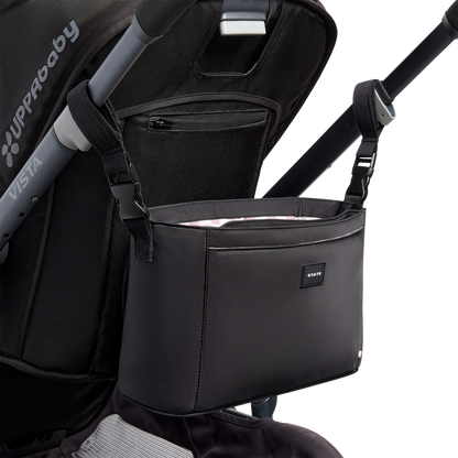 Black stroller organizer attached to a stroller on a white background