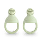 Two light green silicone teething rings on a white background