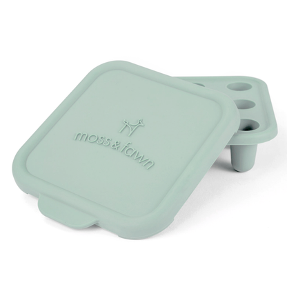 Mint green silicone lid with 'moss & fawn' branding on a white background