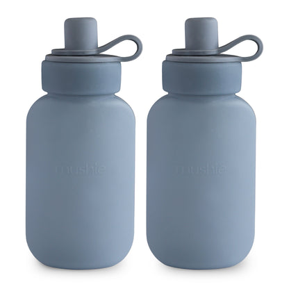 Two blue water bottles with silicone lids on a white background