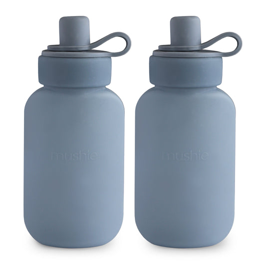 Two blue water bottles with silicone lids on a white background