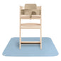 Wooden high chair with beige seat on a blue mat against a white background
